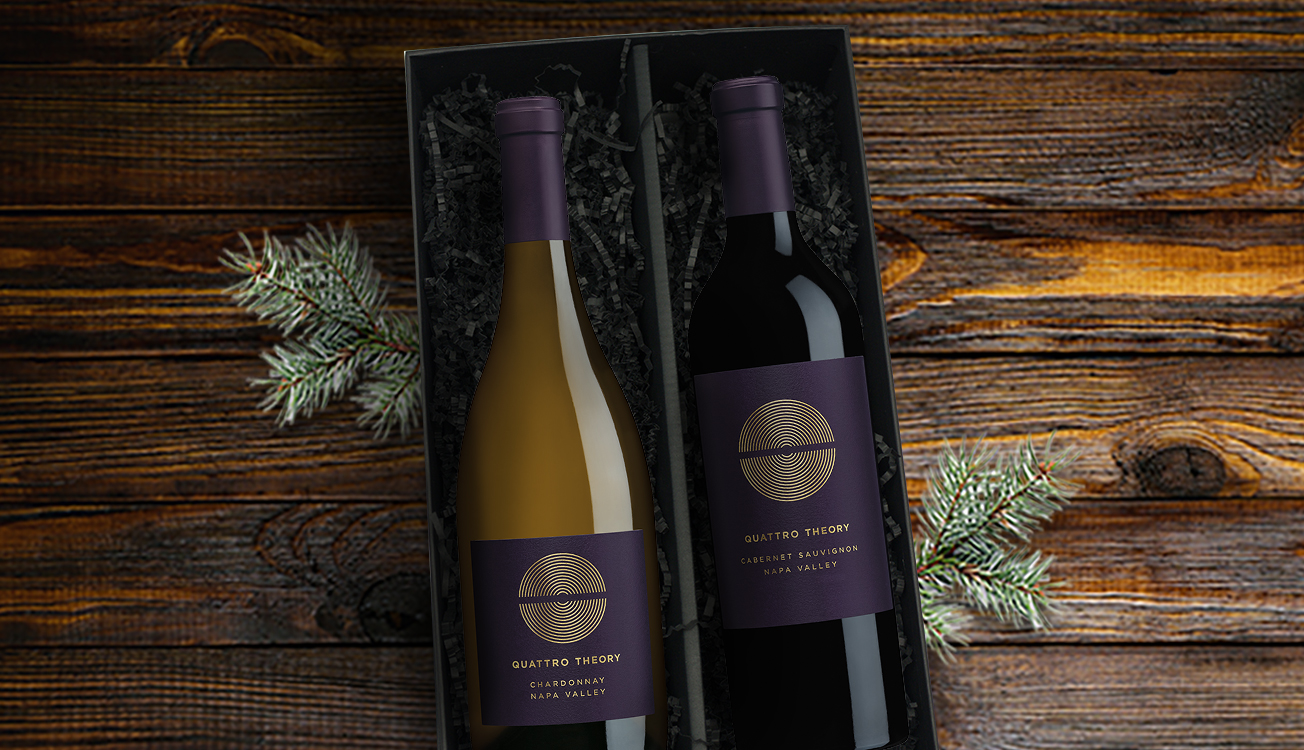 Gift box of Quattro theory wines on a wooden table with fir branches