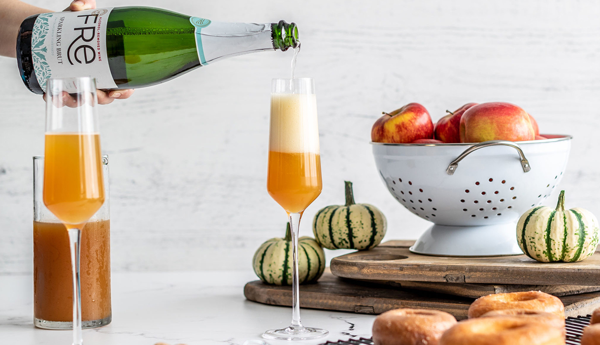 pouring FRE alcohol-removed sparkling brut into a champagne flute of apple cider