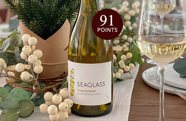 bottle and glasses of SEAGLASS chardonnay on a holiday dining table, rated 91 points