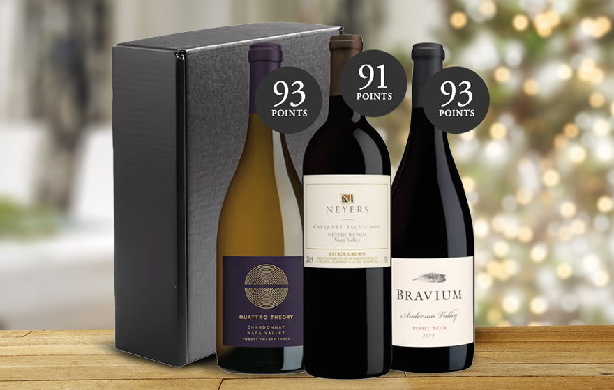 a One Stop Wine Shop holiday wine gift set of top-rated wines on a kitchen table with a Christmas tree in the background