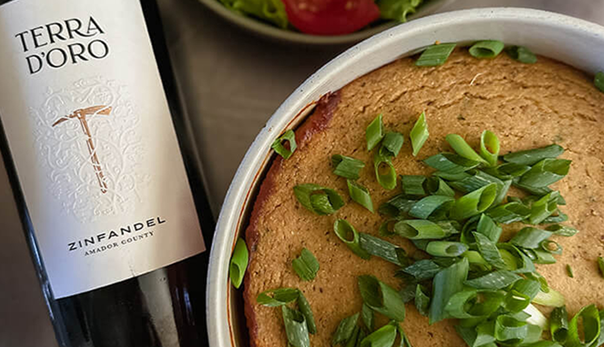 Cornbread crusted vegan chili next to a bottle of Terra d'Oro Zinfandel.